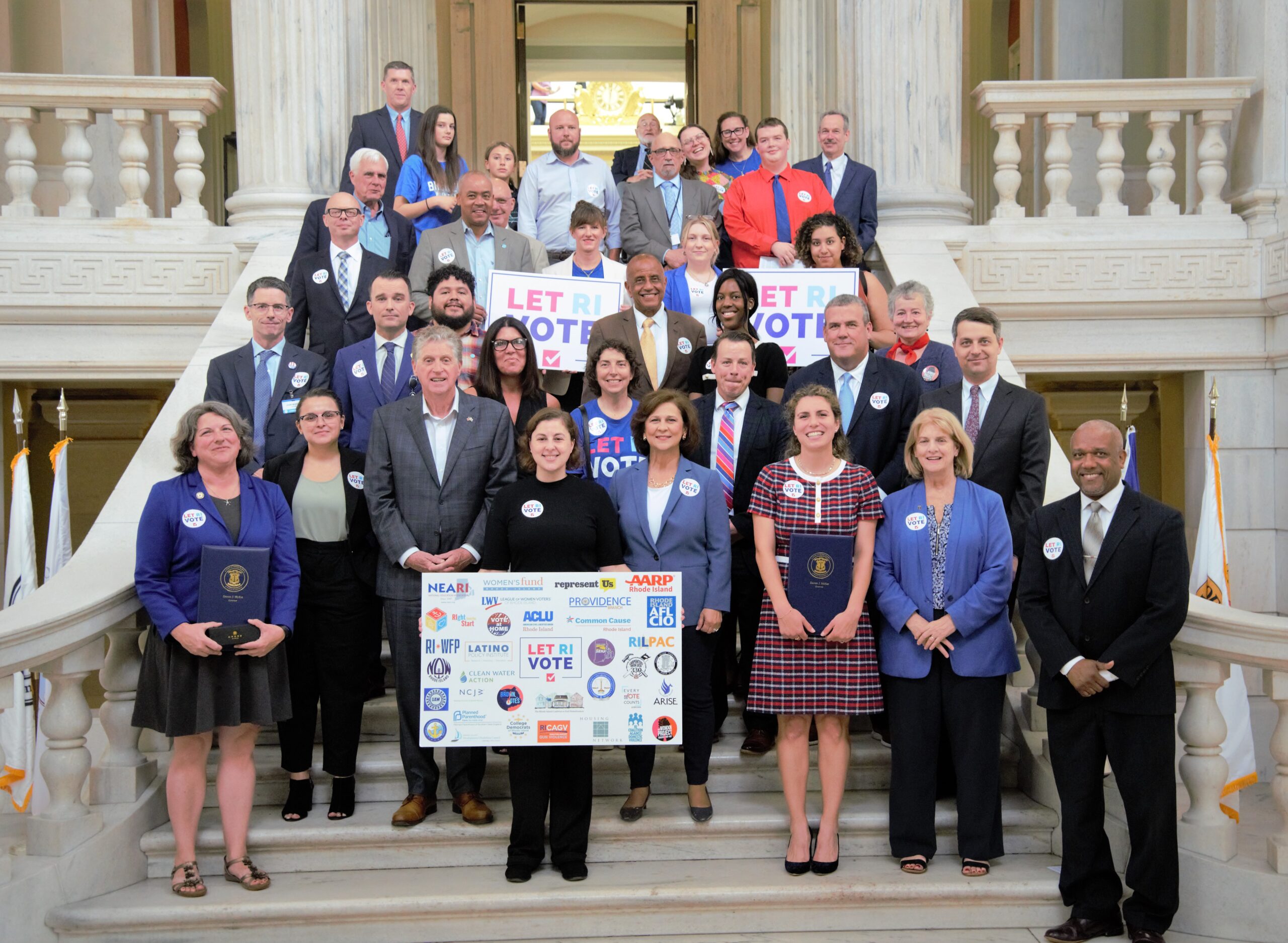 Advocates pictured after the bill signing for the Let RI Vote Act