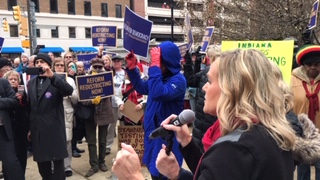 rally with speakers and people with signs