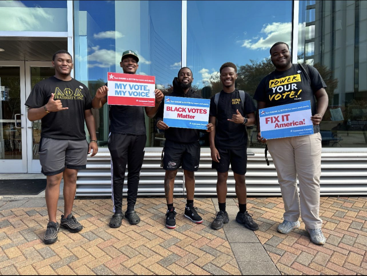 Five members of Alpha Phi Alpha Fraternity at Jackson state with vote rally signs